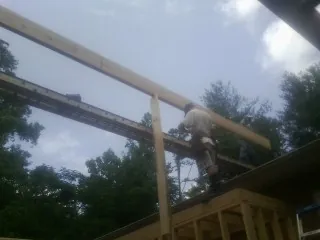 Carpenter setting a ridge beam over a new addition frame — Ice Dam Removal by Roofing Brothers in Nebraska City