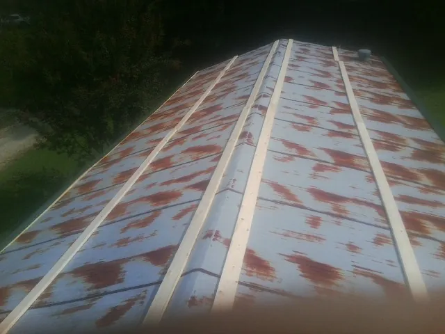 Rusted metal roof panels with new wood purlins before replacement — Storm Damage Roof Repair in Nebraska City by Roofing Brothers