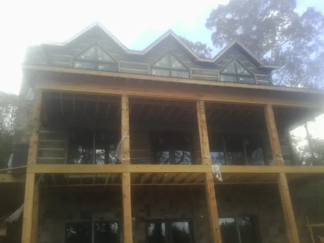 Dormers and porch framing on a large log home under construction — Roof Coating work by our crew in Nebraska City
