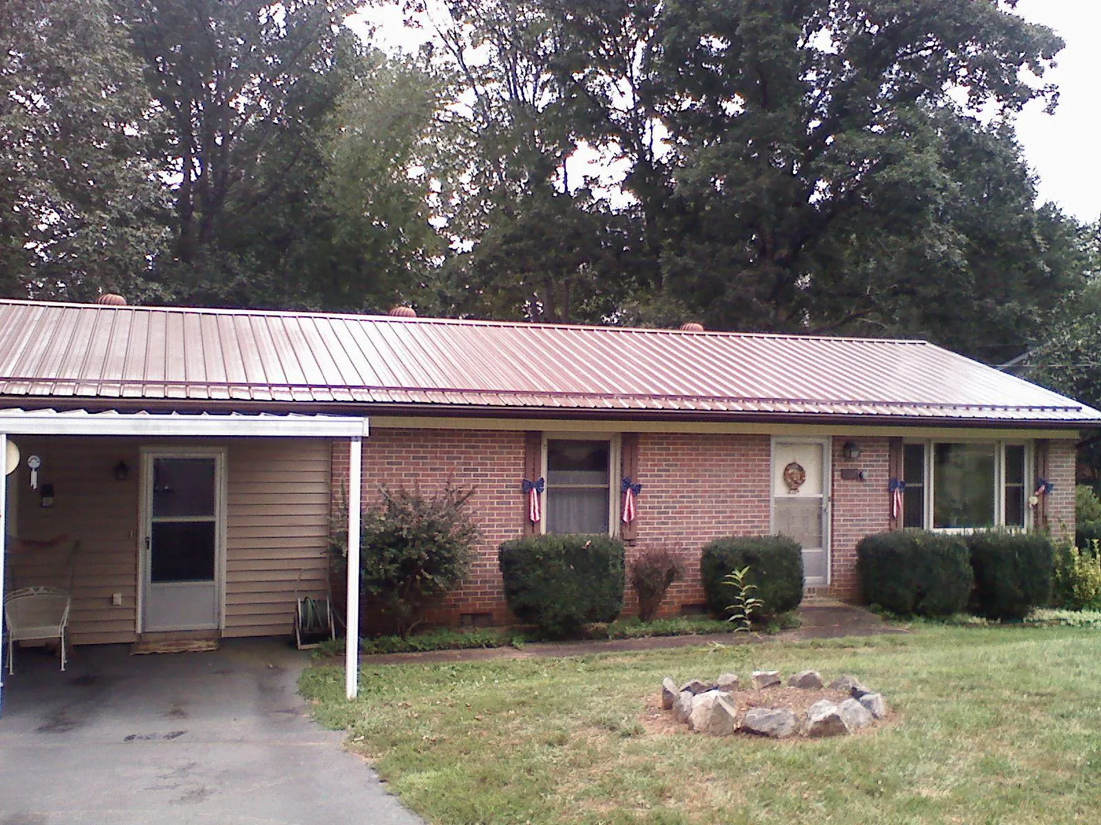 Bronze metal roof and carport on a brick ranch home — Roof Repair work by our crew in Nebraska City